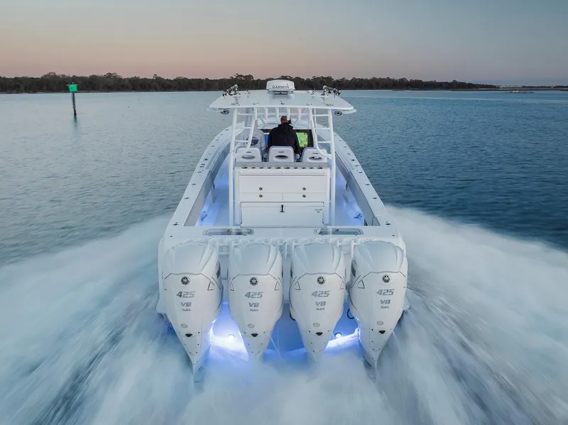 Slide: The Image of 2021 Contender 44 ST boat with four engines cruising on calm water at sunset. - 11