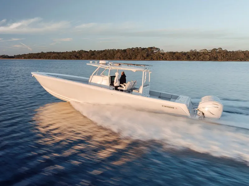Slide: The Image of 2021 Contender 44 ST boat cruising on calm water at sunset. - 13