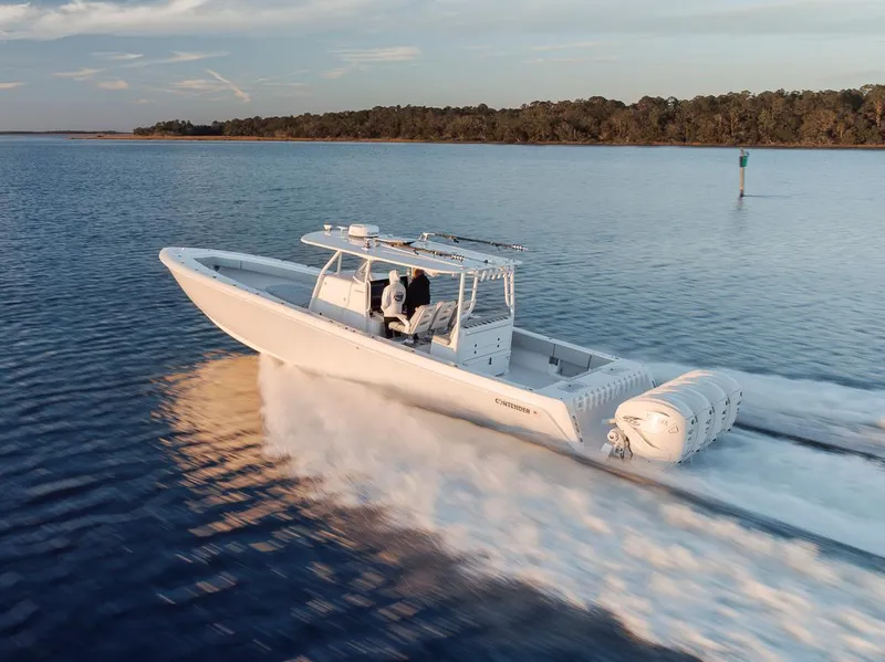 Slide: The Image of 2021 Contender 44 ST boat cruising on calm water at sunset. - 14