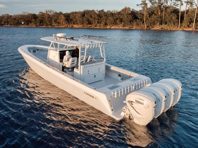 Slide: The Image of 2021 Contender 44 ST boat with triple Yamaha engines on a calm lake. - 7
