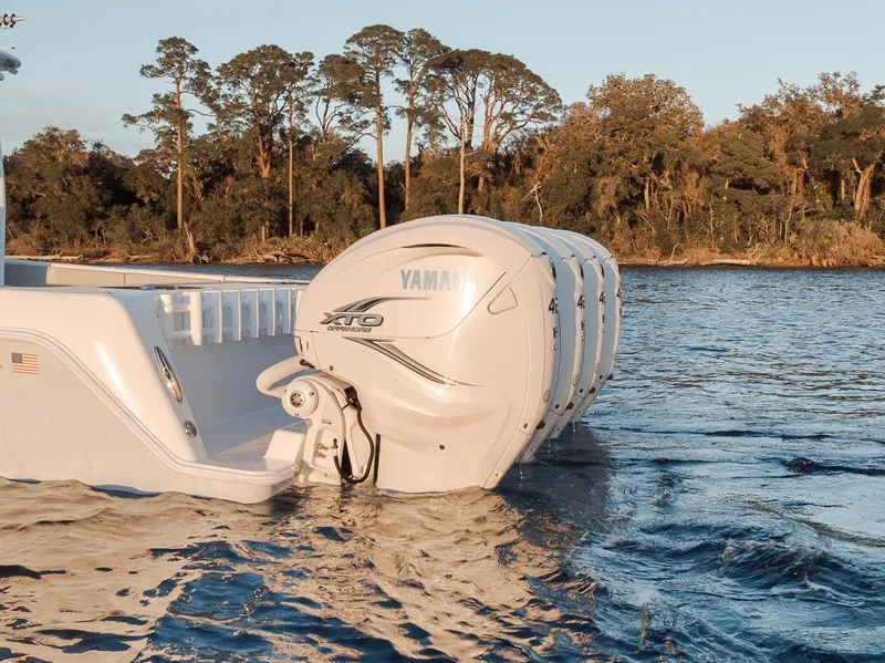 Slide: The Image of 2021 Contender 44 ST boat with Yamaha outboard engines on a serene waterway. - 8