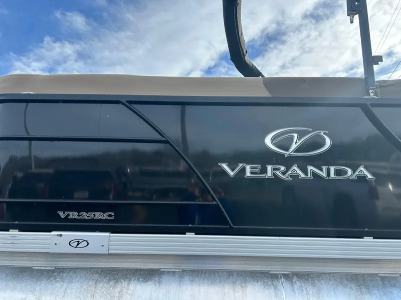 Slide: The Image of 2022 Veranda Relax VR25RC boat, black exterior, logo visible under blue sky. - 11