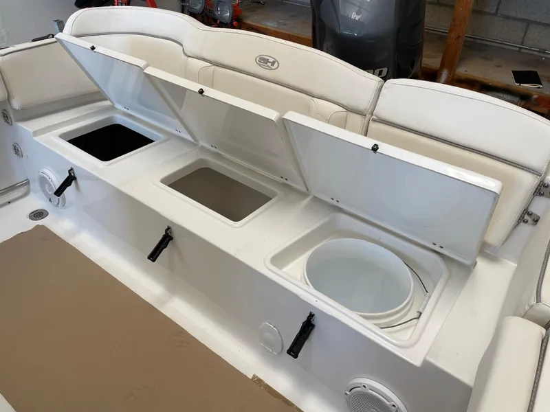 Slide: The Image of 2023 Sea Hunt Ultra 229 boat with open storage compartments and seating. - 15