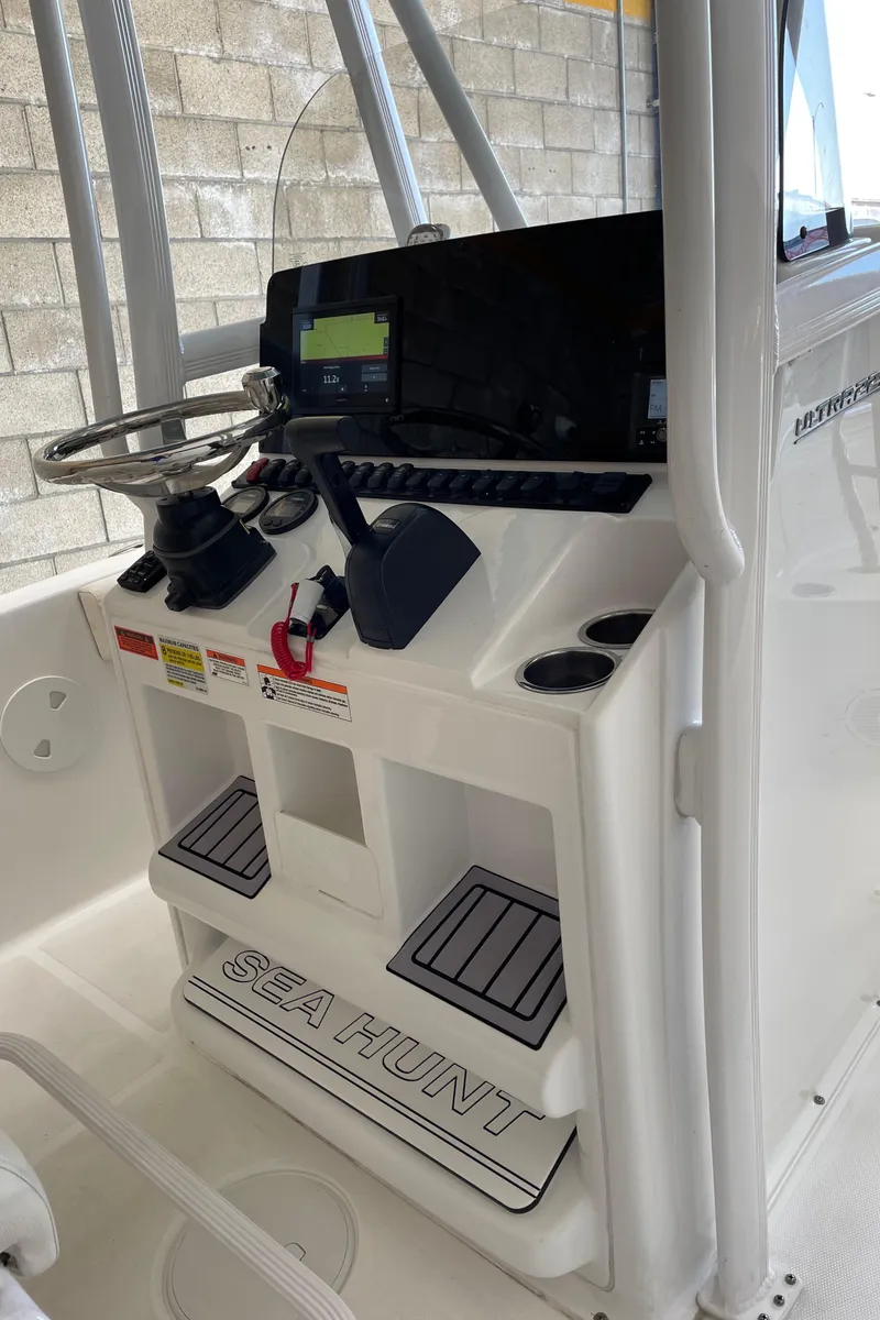 Slide: The Image of 2023 Sea Hunt Ultra 229 boat console with steering wheel and electronic display. - 44