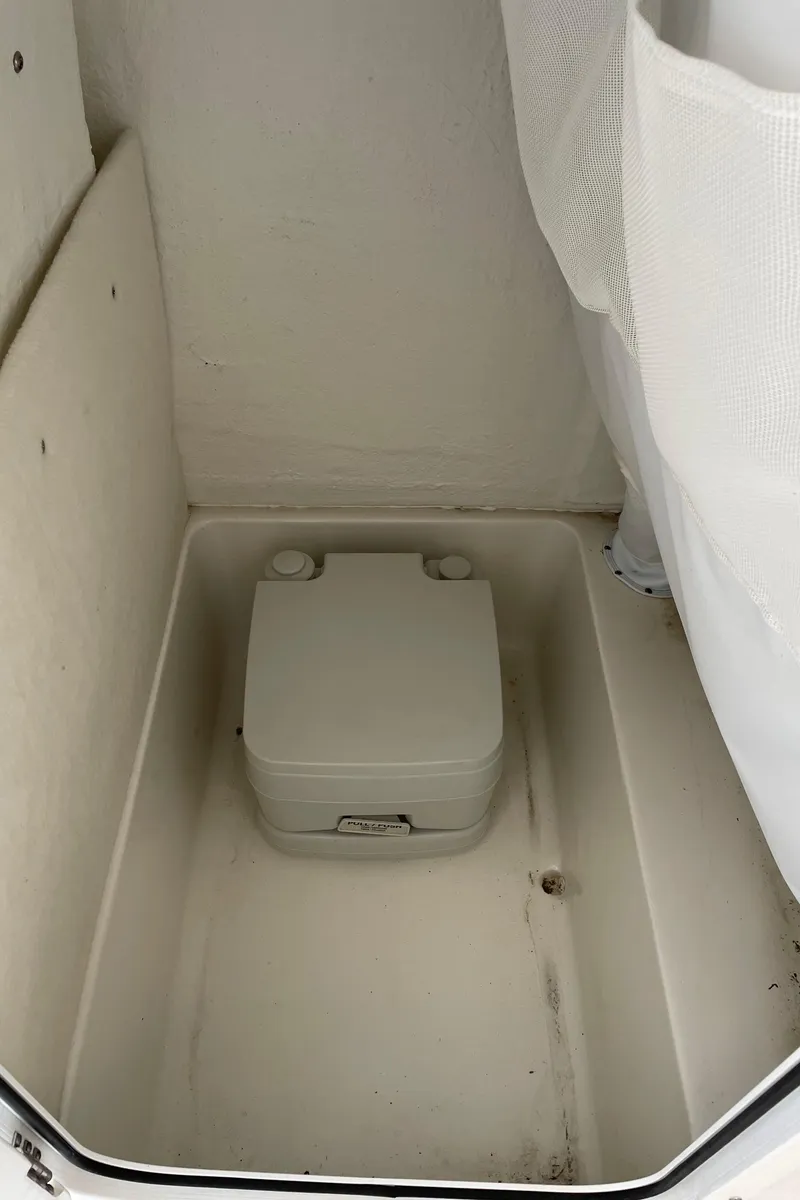 Slide: The Image of 2023 Sea Hunt Ultra 229 boat interior with portable toilet. - 46