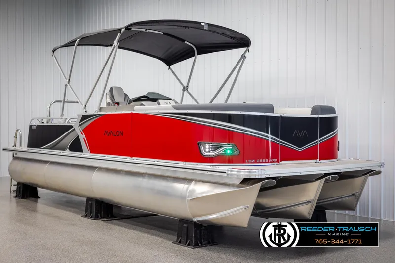 Slide: The Image of 2025 Avalon LSZ VRB pontoon boat with red and black design in showroom. - 3