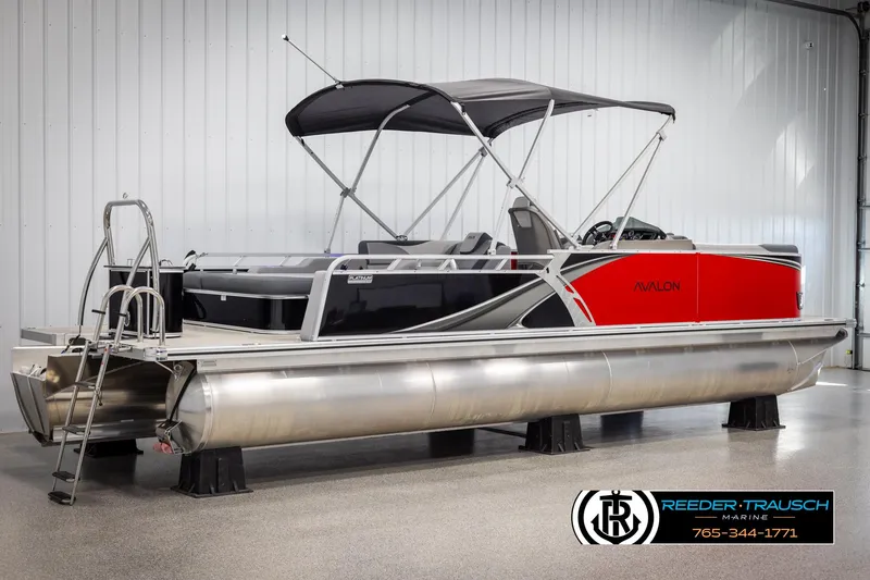 Slide: The Image of 2025 Avalon LSZ VRB pontoon boat with red and black design in showroom. - 6