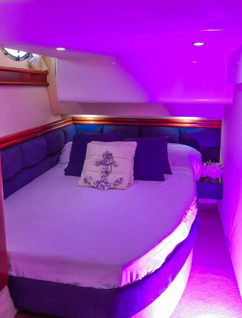 Slide: The Image of Luxurious cabin interior of 2006 Fairline 50 yacht with ambient purple lighting. - 16