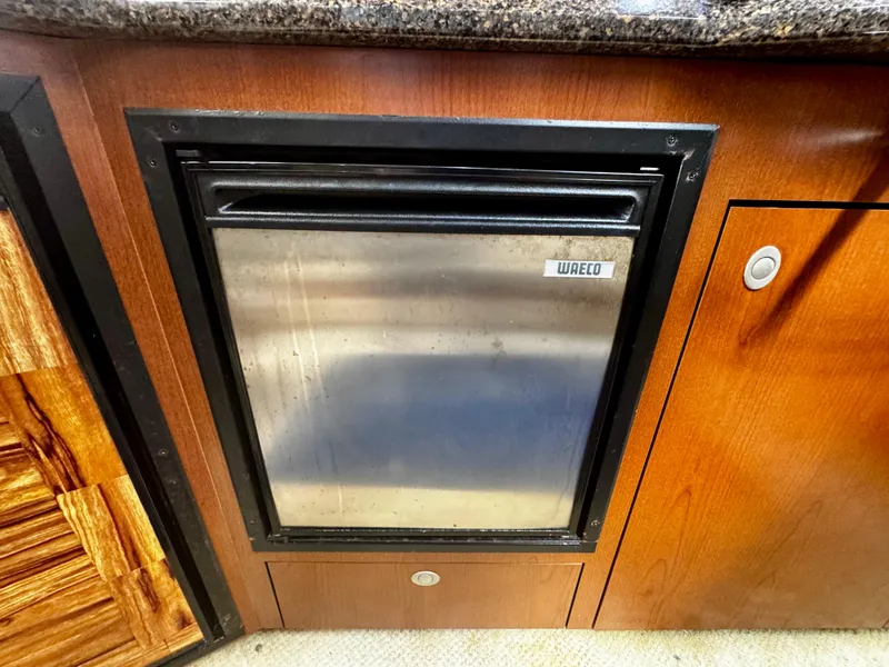 Slide: The Image of Built-in fridge on 2007 Sea Ray 40 Sundancer yacht, featuring wood cabinetry and granite countertop. - 21