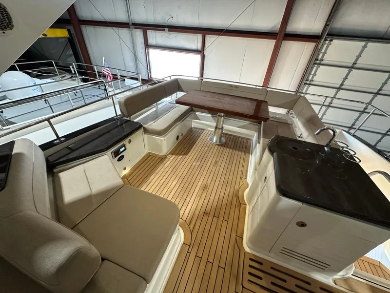 Slide: The Image of 2015 Sea Ray L650 Fly yacht interior with seating and table on teak deck. - 11