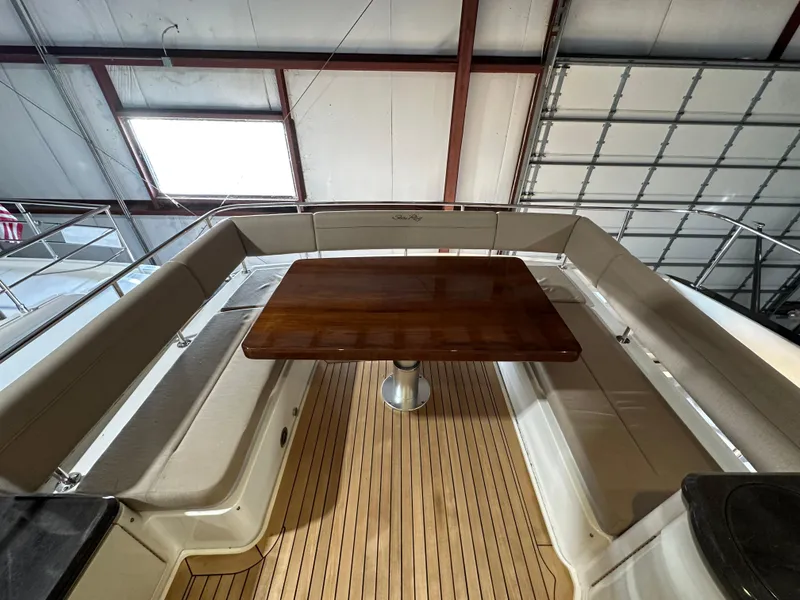 Slide: The Image of 2015 Sea Ray L650 Fly yacht interior with wooden table and cushioned seating. - 12