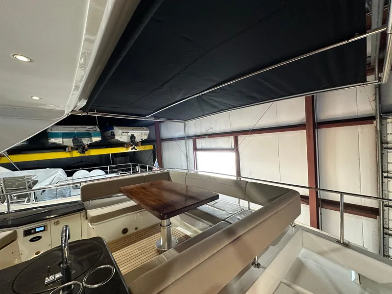 Slide: The Image of 2015 Sea Ray L650 Fly yacht interior with seating and table in a covered area. - 13