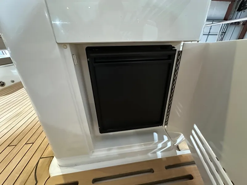 Slide: The Image of 2015 Sea Ray L650 Fly yacht interior with built-in mini fridge on teak deck. - 16