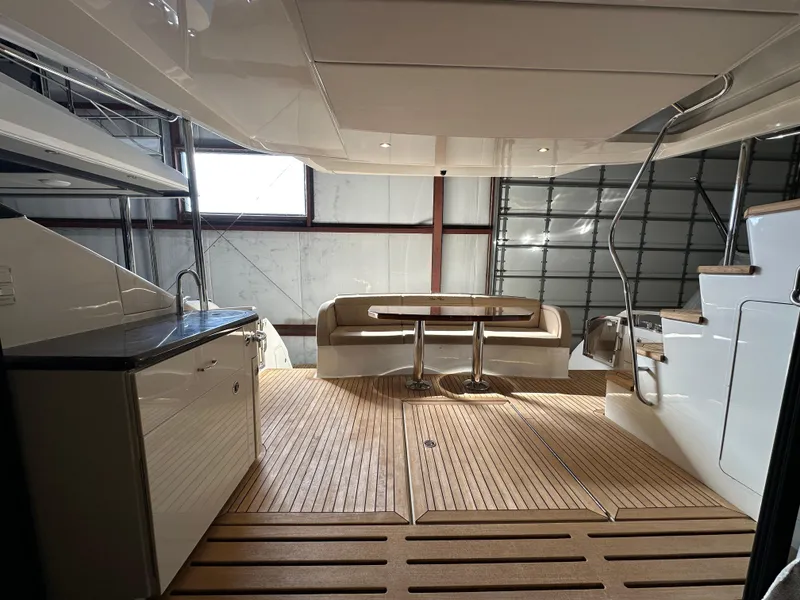 Slide: The Image of 2015 Sea Ray L650 Fly yacht interior with wooden flooring and seating area. - 23