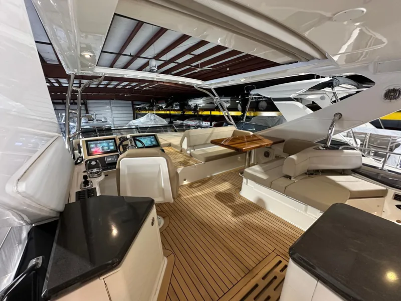 Slide: The Image of 2015 Sea Ray L650 Fly yacht interior with modern helm, seating, and wooden flooring. - 3