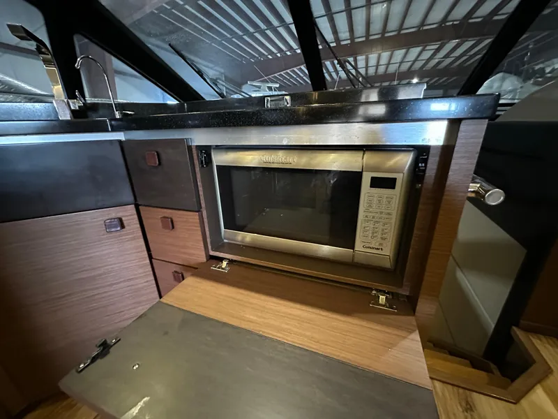 Slide: The Image of Modern kitchen with built-in microwave on 2015 Sea Ray L650 Fly yacht. - 38
