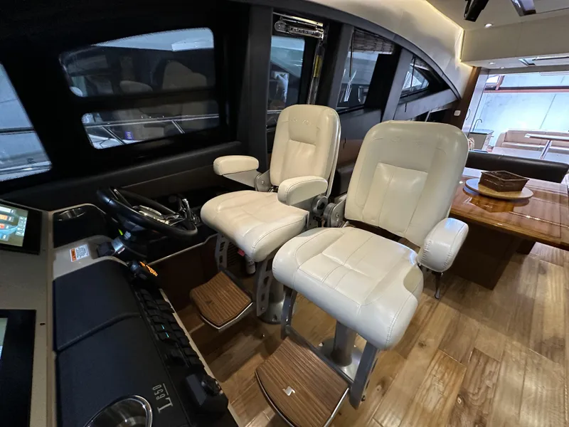 Slide: The Image of Interior of 2015 Sea Ray L650 Fly yacht with plush captain chairs and wooden flooring. - 41