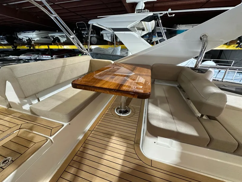Slide: The Image of 2015 Sea Ray L650 Fly yacht interior with wooden table and cushioned seating. - 5