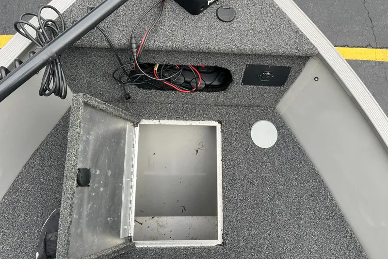 Slide: The Image of 2011 Lowe FM 165 boat interior with open storage compartment and visible wiring. - 16