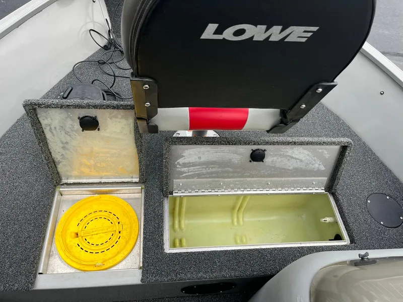 Slide: The Image of 2011 Lowe FM 165 boat interior with storage compartments and seat. - 17