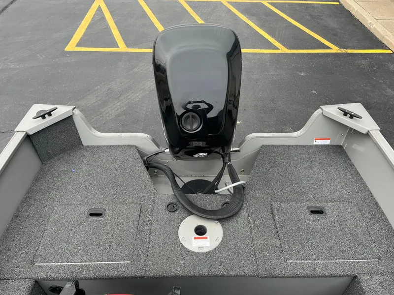 Slide: The Image of 2011 Lowe FM 165 boat with motor, parked on asphalt with yellow lines. - 20