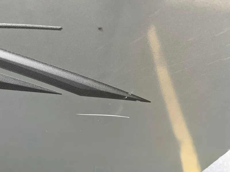 Slide: The Image of Close-up of a 2011 Lowe FM 165 boat with scratches and graphic detail. - 28