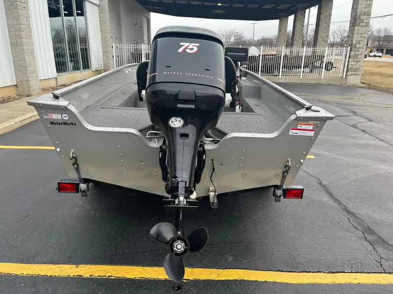 Slide: The Image of 2011 Lowe FM 165 boat with 75 HP outboard motor, parked outdoors. - 4