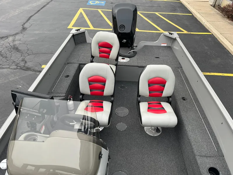 Slide: The Image of 2011 Lowe FM 165 boat with red and gray seating, parked in a lot. - 9