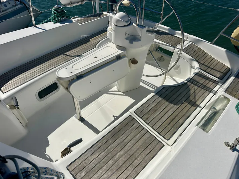 Slide: The Image of 2002 Beneteau Oceanis Clipper 393 yacht cockpit with wooden decking and steering wheel. - 13