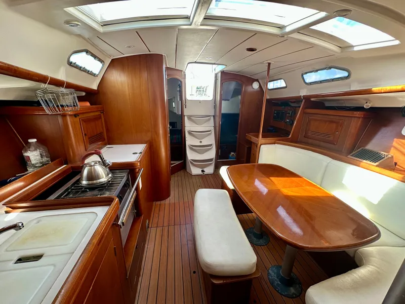 Slide: The Image of Interior of 2002 Beneteau Oceanis Clipper 393 yacht with wooden furnishings and dining area. - 19