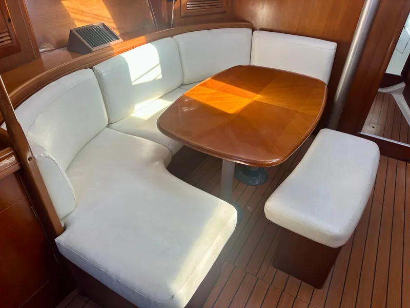 Slide: The Image of Interior of 2002 Beneteau Oceanis Clipper 393 with wooden table and white seating. - 24