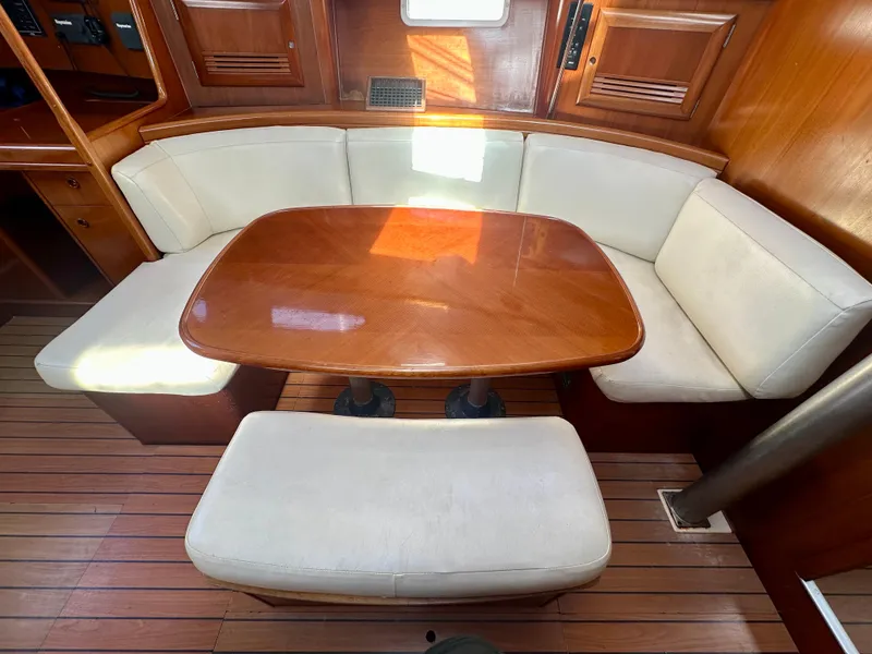 Slide: The Image of Interior of 2002 Beneteau Oceanis Clipper 393 with wooden table and cushioned seating. - 25