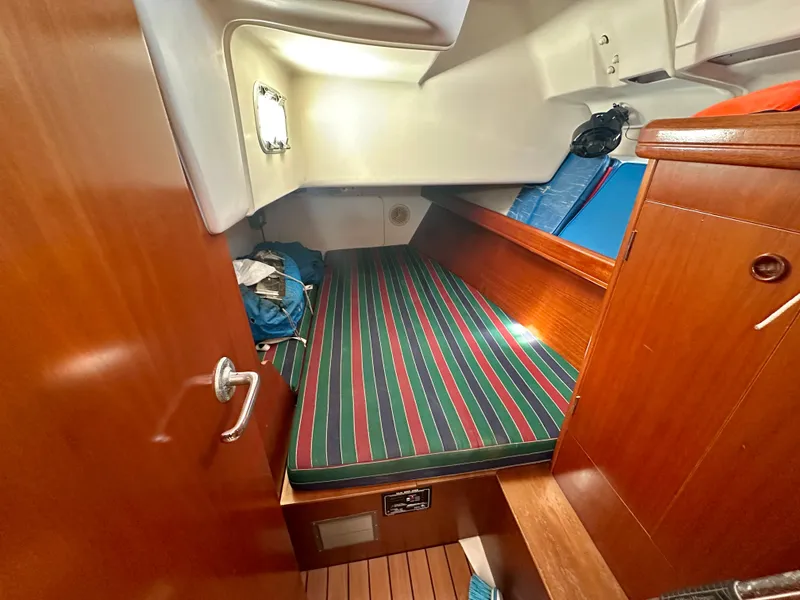 Slide: The Image of Cozy cabin interior of 2002 Beneteau Oceanis Clipper 393 sailboat with striped bedding. - 33