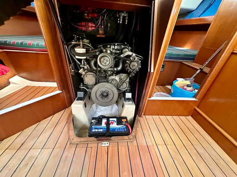 Slide: The Image of Engine compartment of 2002 Beneteau Oceanis Clipper 393 sailboat, featuring visible battery and wooden flooring. - 34