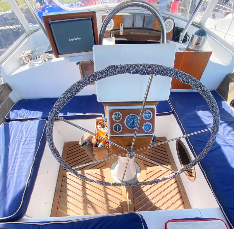 Slide: The Image of 1975 Whitby 42 Center Cockpit with steering wheel, navigation instruments, and blue seating. - 10