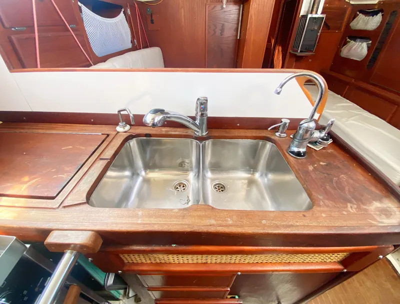 Slide: The Image of 1975 Whitby 42 Center Cockpit kitchen sink with dual faucets and wooden countertop. - 15