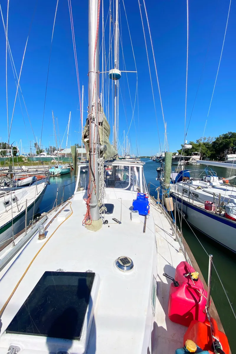 Slide: The Image of 1975 Whitby 42 Center Cockpit sailboat docked in a sunny marina. - 2