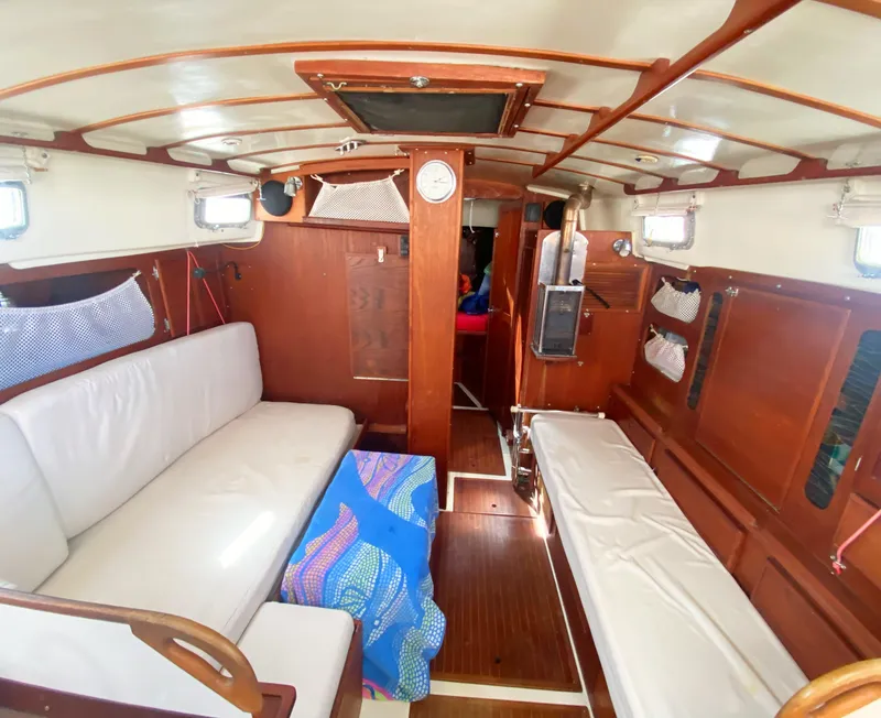 Slide: The Image of Interior of 1975 Whitby 42 Center Cockpit sailboat with wooden finish and white seating. - 22