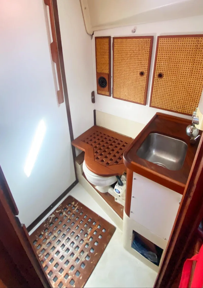 Slide: The Image of 1975 Whitby 42 Center Cockpit bathroom with wooden accents and compact sink. - 27