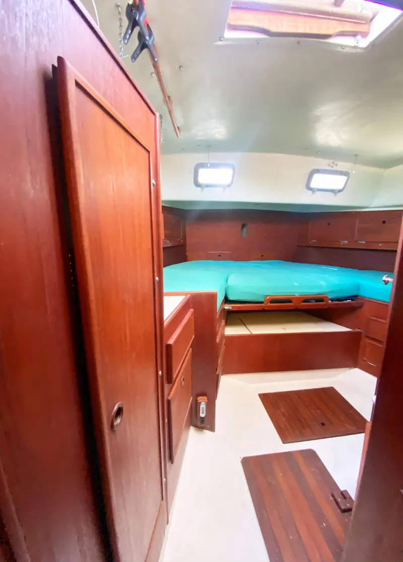 Slide: The Image of Interior of 1975 Whitby 42 Center Cockpit sailboat with wood paneling and teal bedding. - 28