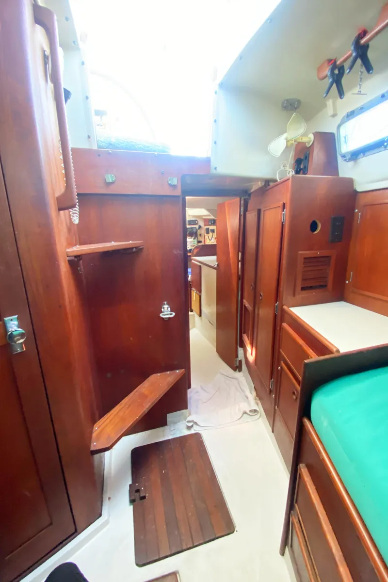 Slide: The Image of Interior of 1975 Whitby 42 Center Cockpit sailboat with wooden cabinetry and green bedding. - 31