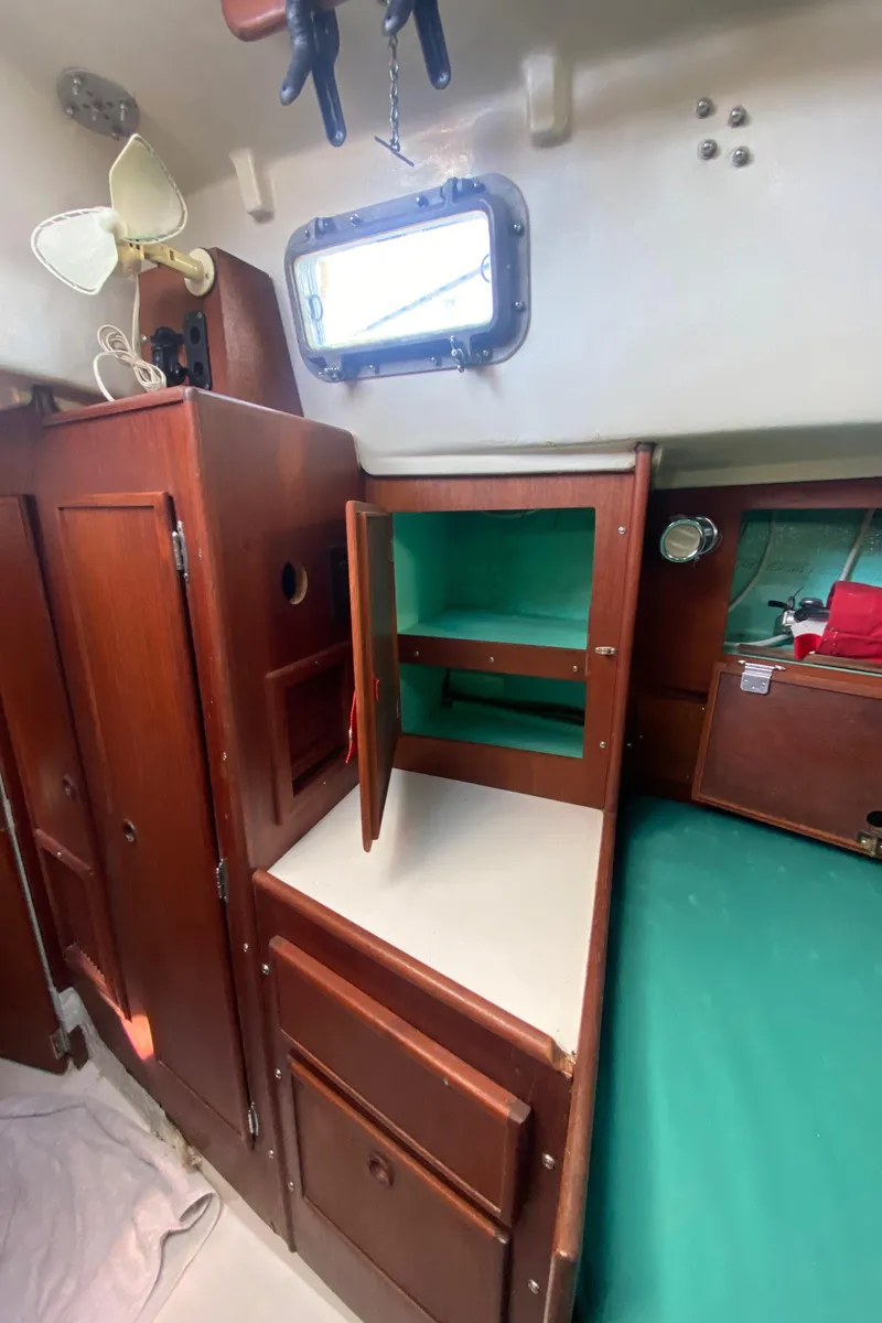Slide: The Image of Interior of 1975 Whitby 42 Center Cockpit with wooden cabinets and green bedding. - 32