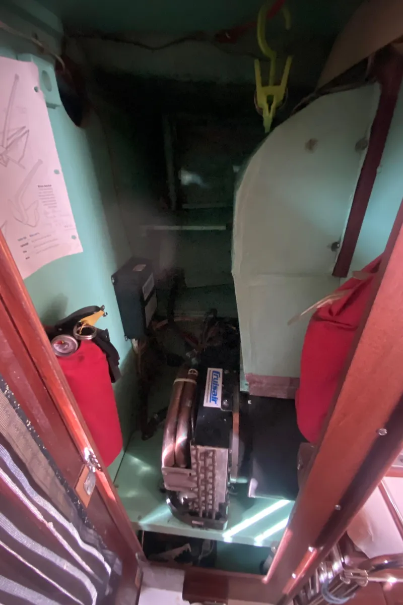 Slide: The Image of Engine room of a 1975 Whitby 42 Center Cockpit sailboat, featuring equipment and storage. - 41