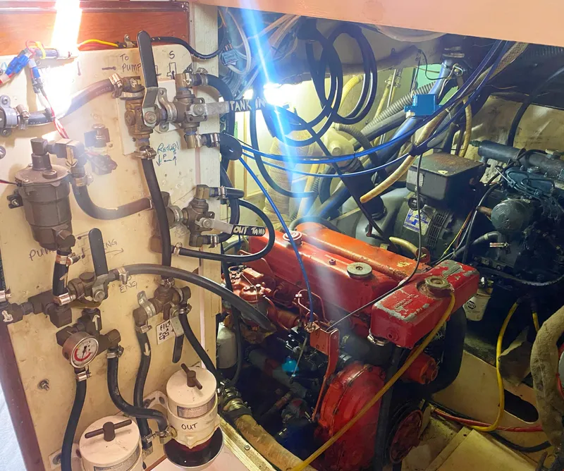 Slide: The Image of Engine room of a 1975 Whitby 42 Center Cockpit sailboat, showcasing mechanical components and wiring. - 43