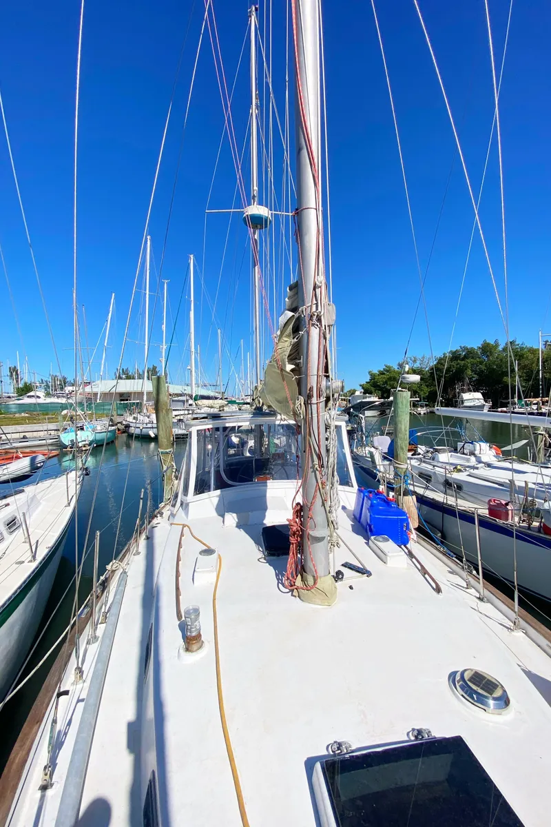 Slide: The Image of 1975 Whitby 42 Center Cockpit sailboat docked in a marina under clear blue skies. - 5