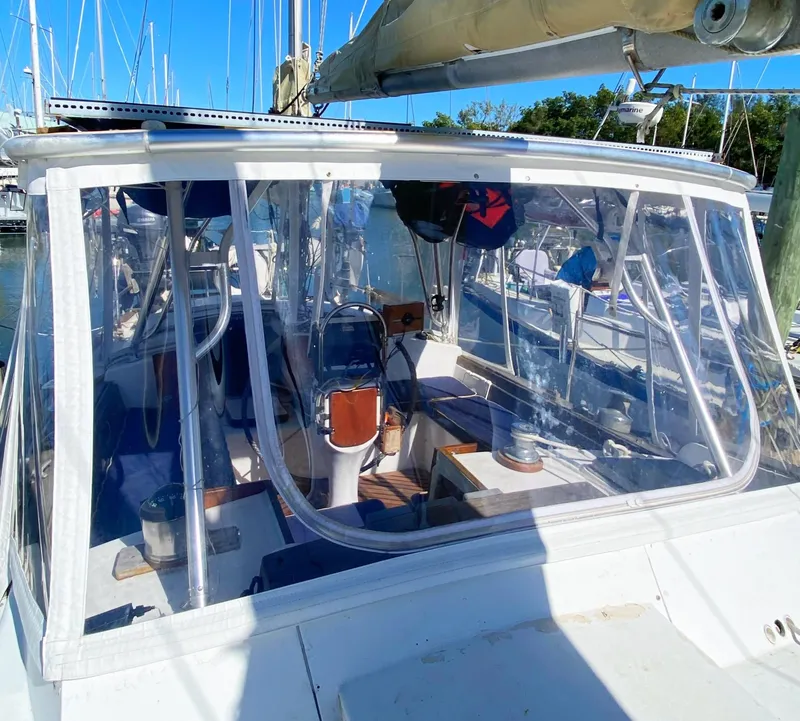 Slide: The Image of 1975 Whitby 42 Center Cockpit sailboat with clear enclosure, docked in a marina. - 6
