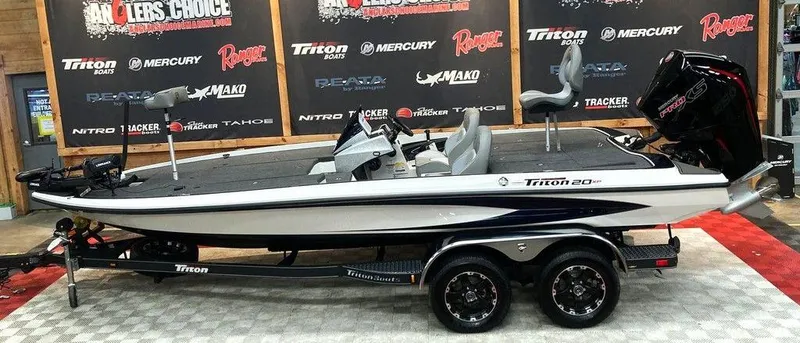 The Image of 2025 Triton 20XP fishing boat on display with dual axle trailer. - 1