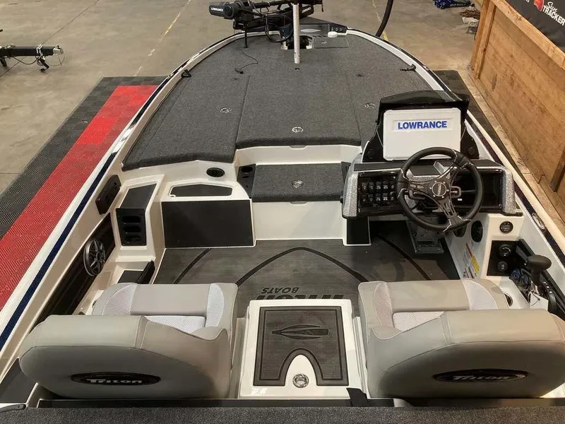 Slide: The Image of 2025 Triton 20XP boat interior with steering wheel, seats, and Lowrance electronics. - 6