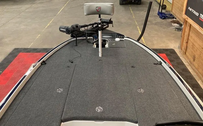 Slide: The Image of 2025 Triton 20XP boat deck with trolling motor and seat in a garage setting. - 8