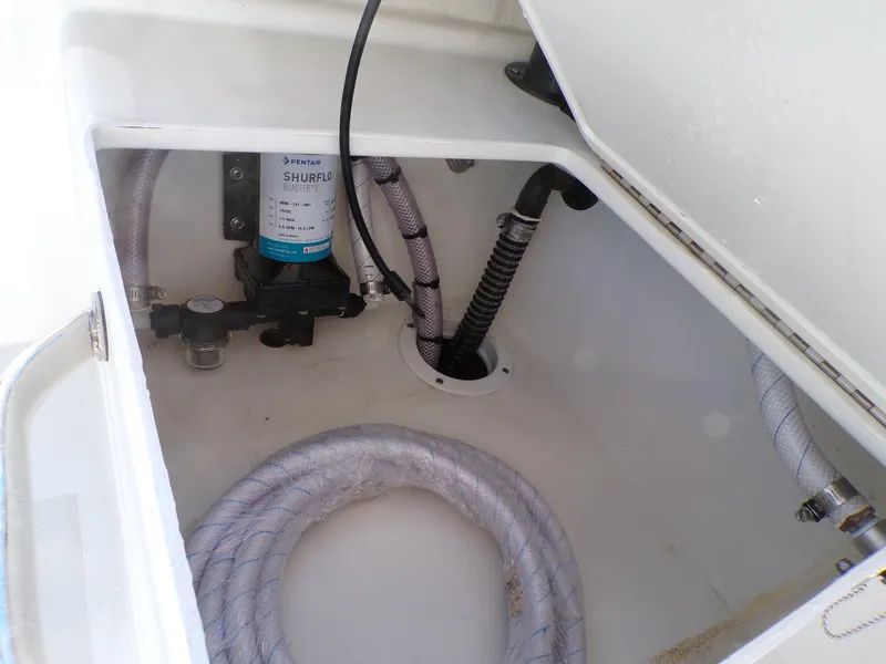 Slide: The Image of 2024 Parker 1801 Center Console boat storage compartment with hoses and pump system. - 12